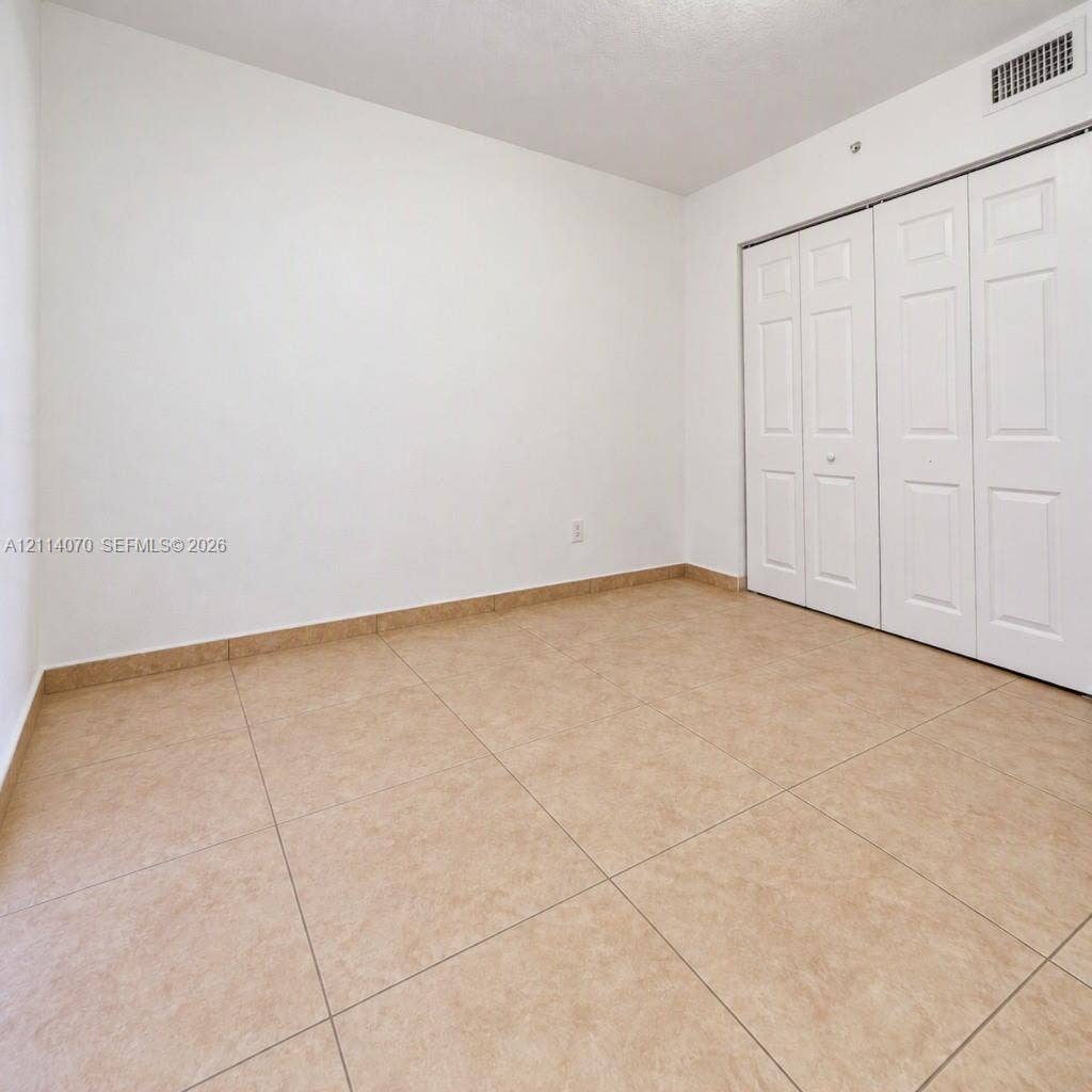 15400 SW 284th Street, #1204, Homestead, Homestead, FL 33033 Neutral-toned tile flooring, white wall finish, and bi-fold closet doors