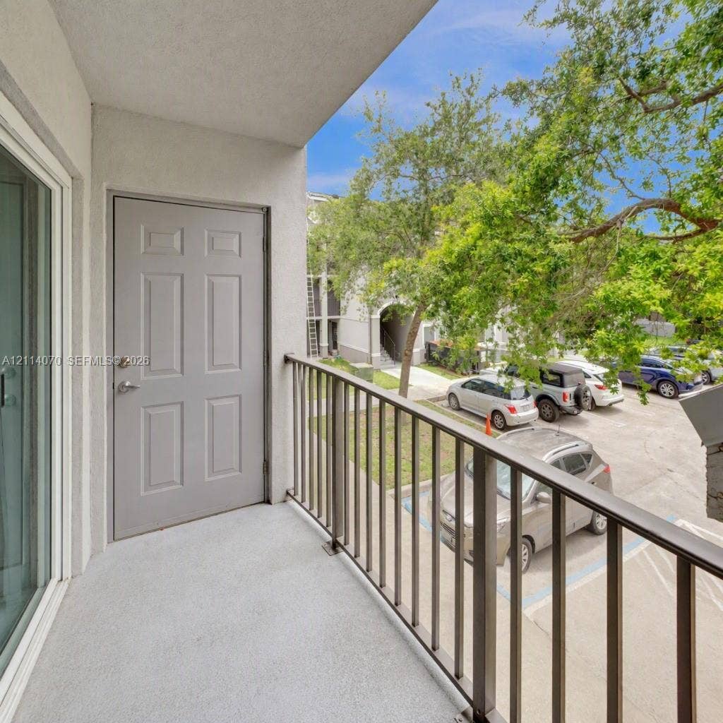 15400 SW 284th Street, #1204, Homestead, Homestead, FL 33033 Covered balcony featuring concrete flooring, a paneled door, and metal railing