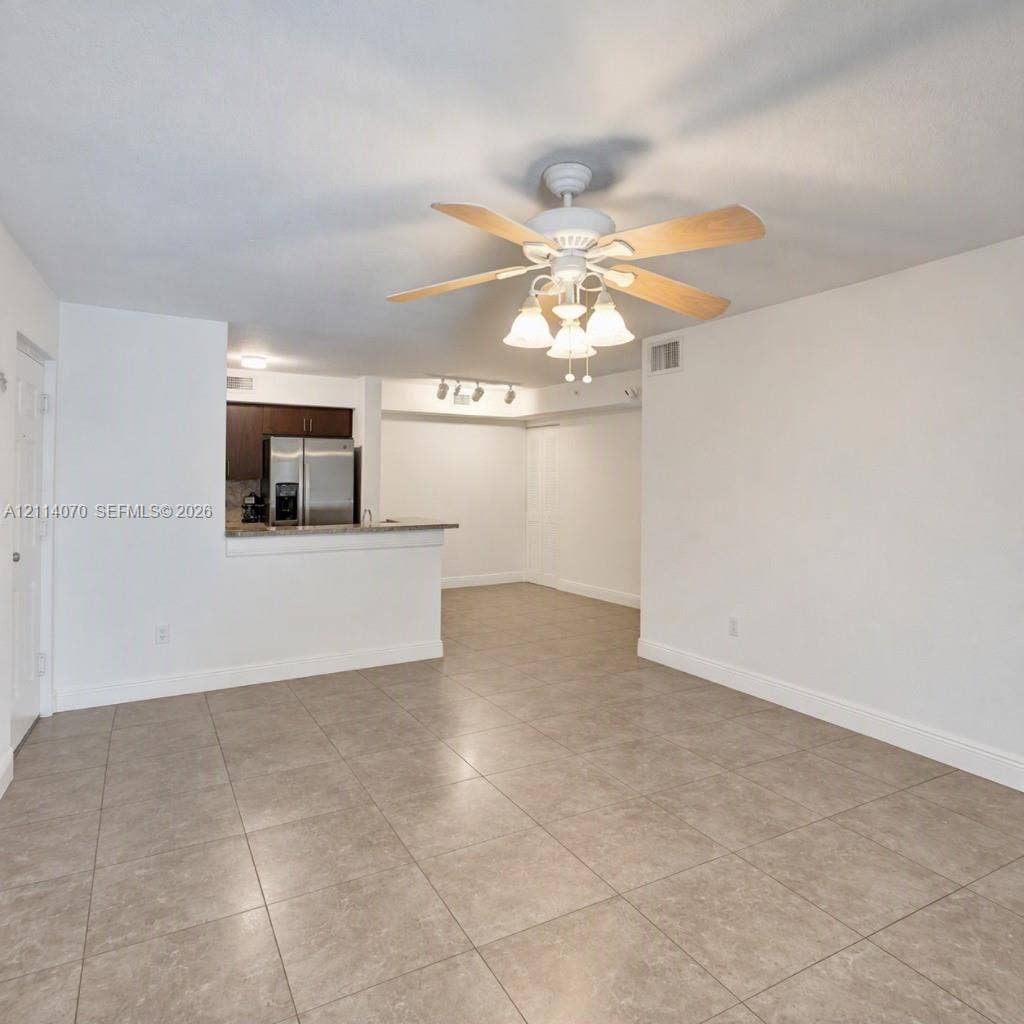 15400 SW 284th Street, #1204, Homestead, Homestead, FL 33033 Large-format tile flooring, central ceiling fan with multi-light fixture, breakfast bar, and stainless steel refrigerator