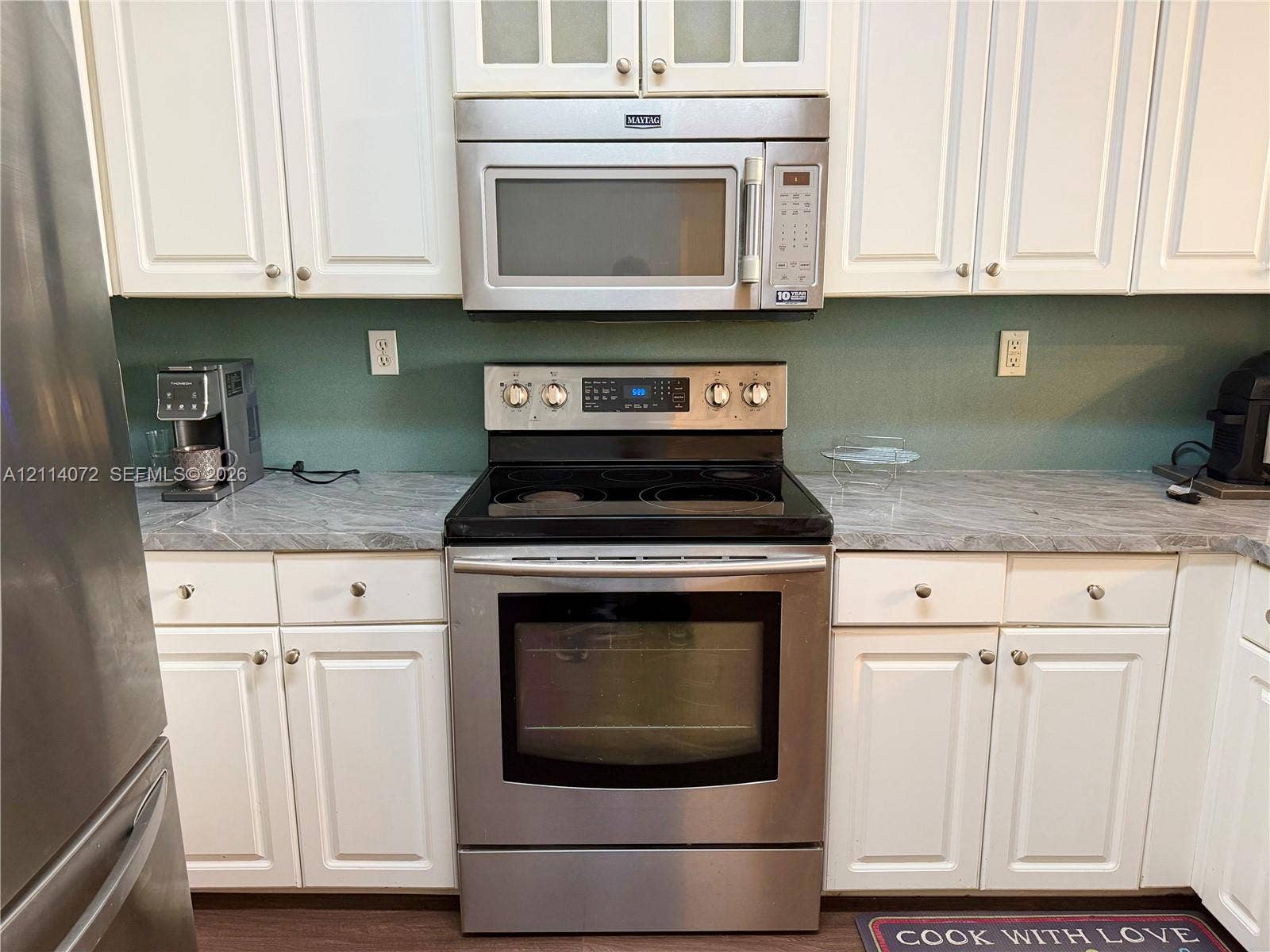 8964 W Flagler Street, #107, Miami, Miami, FL 33174 Kitchen featuring white shaker-style cabinetry, stone-patterned laminate countertops, stainless steel electric range, and stainless steel over-the-range microwave