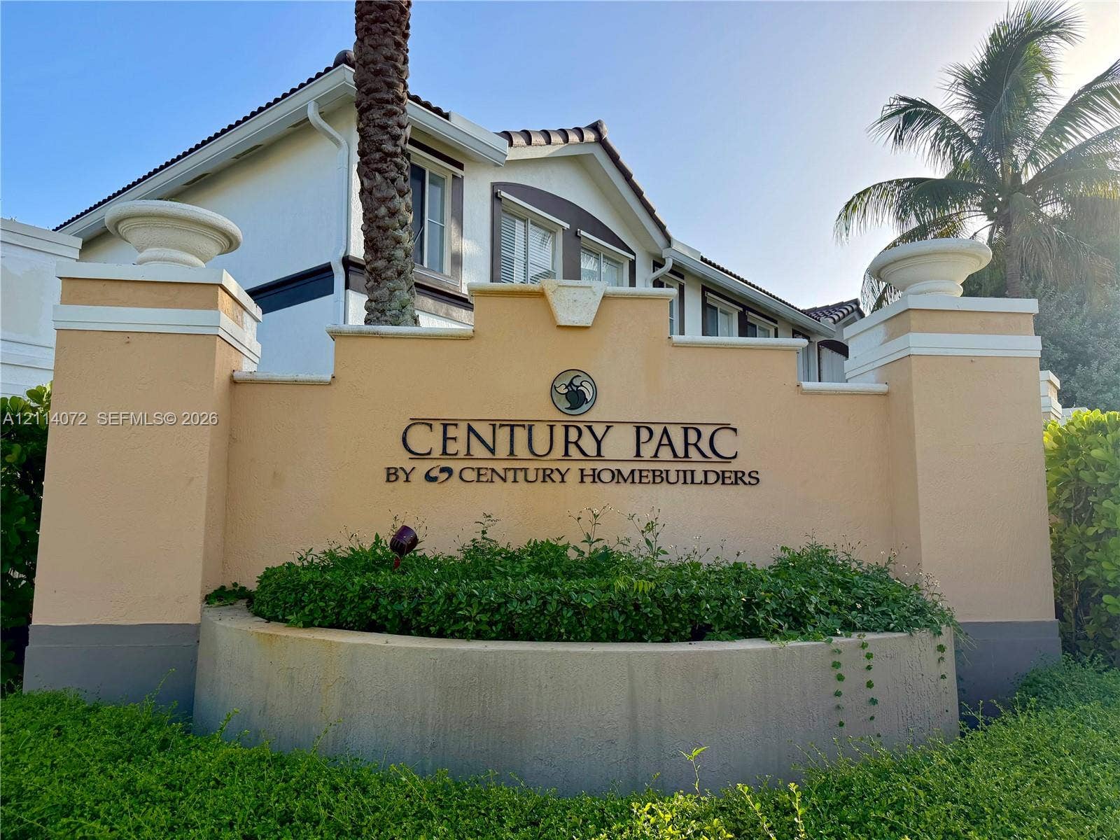 8964 W Flagler Street, #107, Miami, Miami, FL 33174 Stucco masonry monument signage featuring dual stone-capped columns, integrated concrete planter, and professional landscape hedging