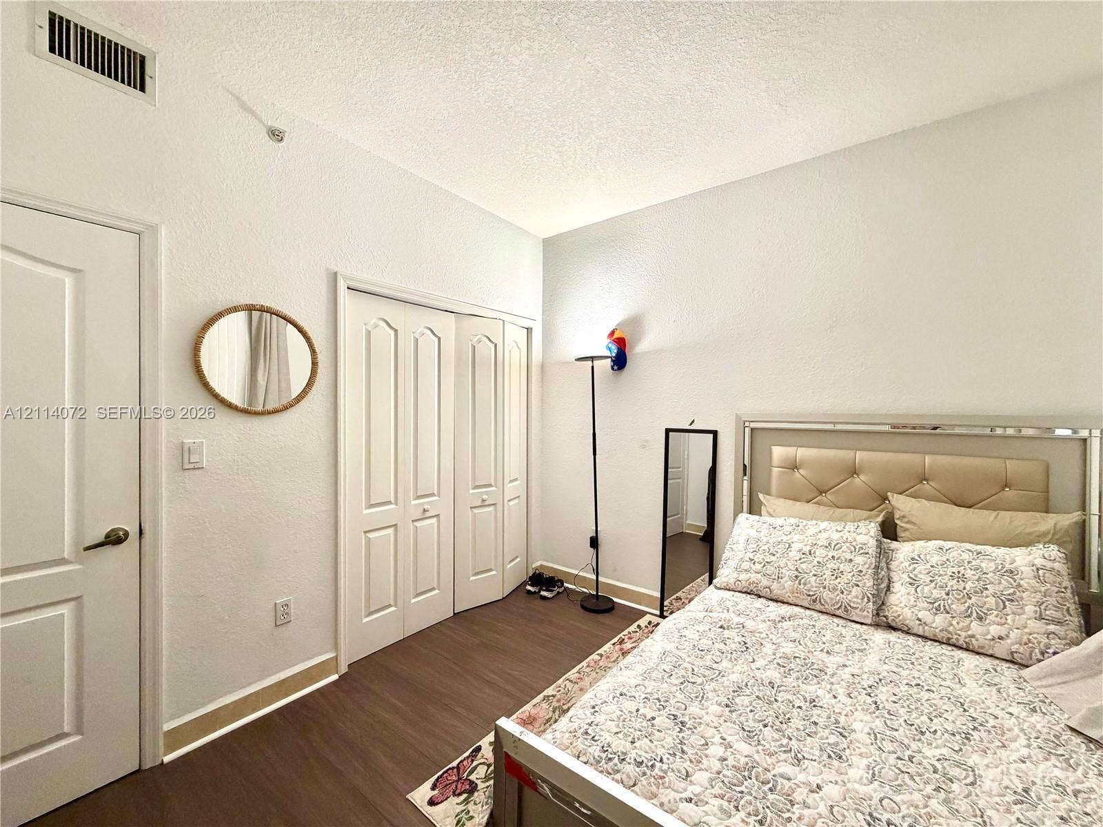 8964 W Flagler Street, #107, Miami, Miami, FL 33174 Room featuring wood-finish flooring, textured ceiling, and bi-fold closet doors