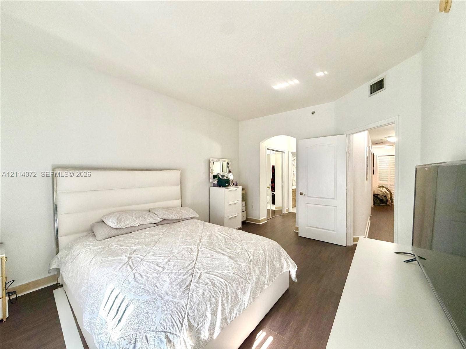 8964 W Flagler Street, #107, Miami, Miami, FL 33174 Wood-finish flooring, high ceilings, and an arched doorway featuring a multi-panel door