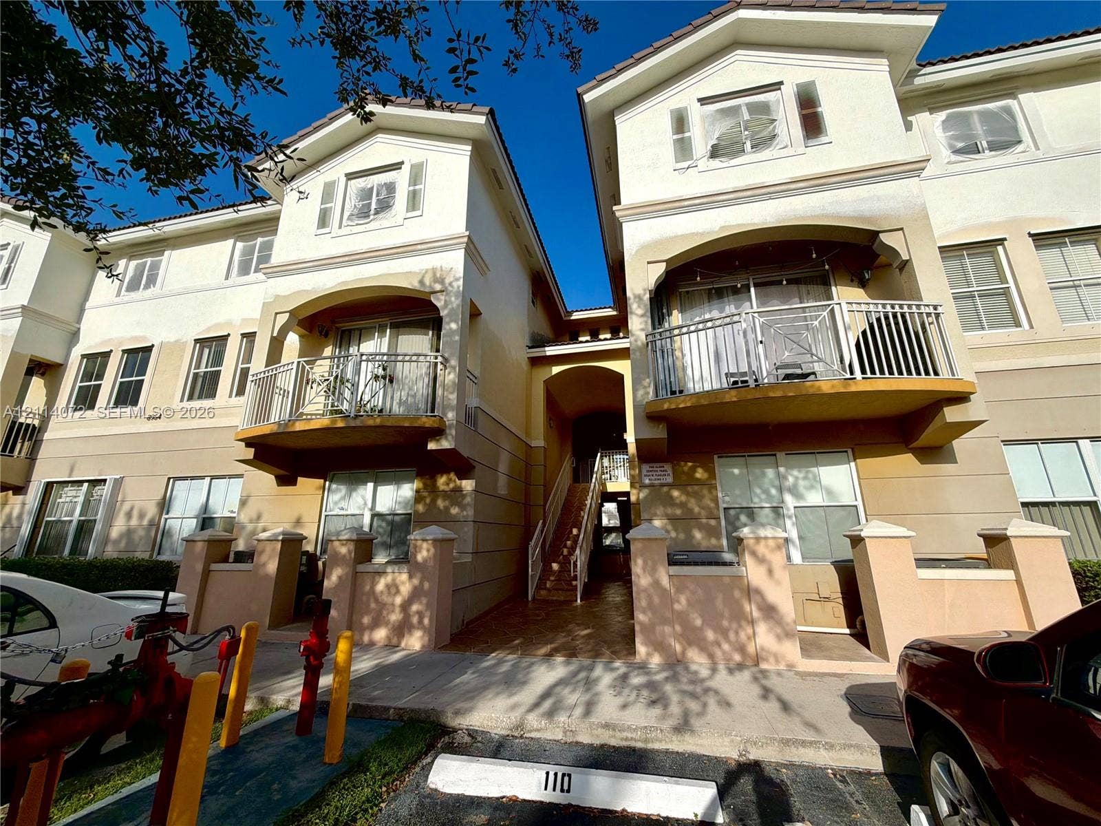 8964 W Flagler Street, #107, Miami, Miami, FL 33174 Stucco exterior featuring multi-level balconies with metal railings, arched architectural details, and tiled roofing