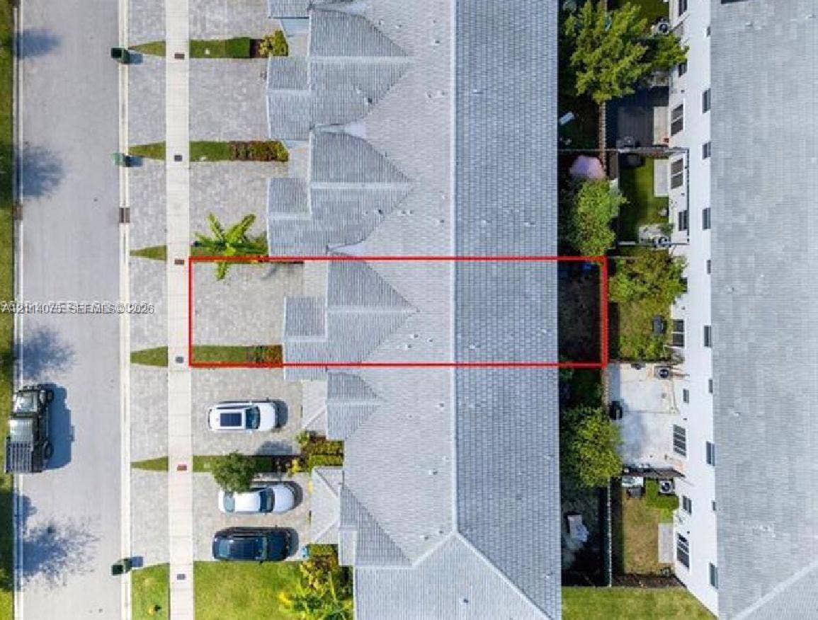 2659 SE 11th Street, Homestead, FL 33035 Aerial perspective of a multi-unit property featuring a paver driveway, shingle roofing, and a private rear ground-level patio space