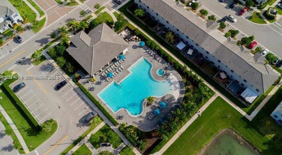 2659 SE 11th Street, Homestead, FL 33035 Community clubhouse featuring a swimming pool, integrated spa, paved pool deck, and landscaped surroundings