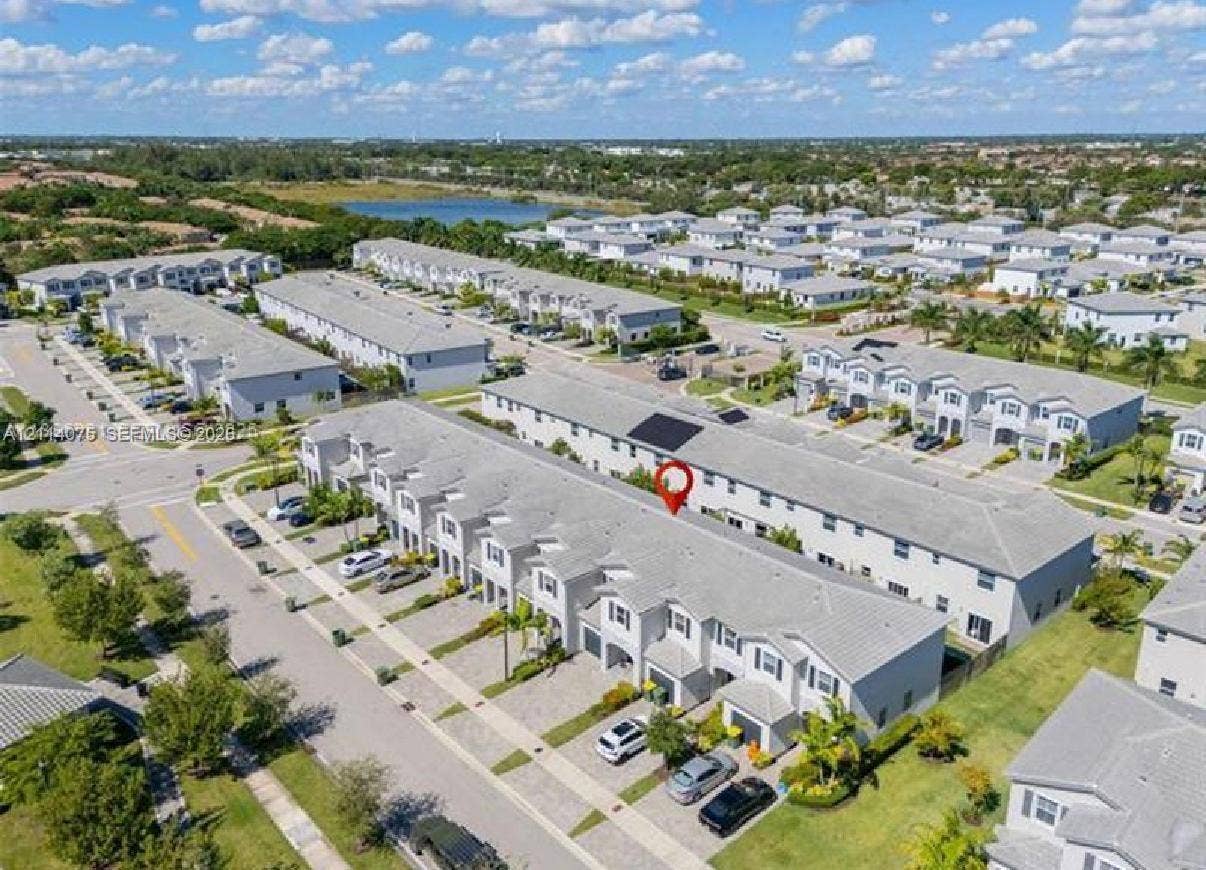 2659 SE 11th Street, Homestead, FL 33035 Aerial perspective of a multi-unit residential complex featuring gray shingle roofing, paved driveways, and surrounding green space
