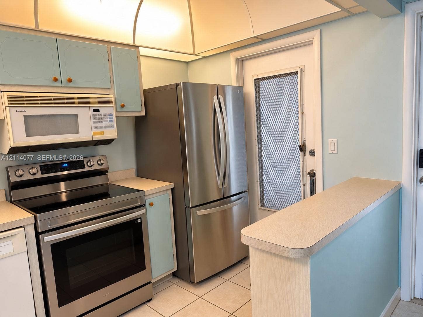 465 Paradise Isle Boulevard, #206, Hallandale Beach, Hallandale Beach, FL 33009 Kitchen featuring stainless steel refrigerator, over-the-range microwave, electric range, laminate countertops, and ceramic tile flooring