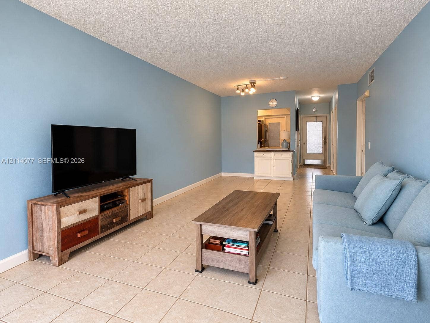 465 Paradise Isle Boulevard, #206, Hallandale Beach, Hallandale Beach, FL 33009 Living space featuring tile flooring, built-in wet bar with cabinetry, and multi-directional track lighting
