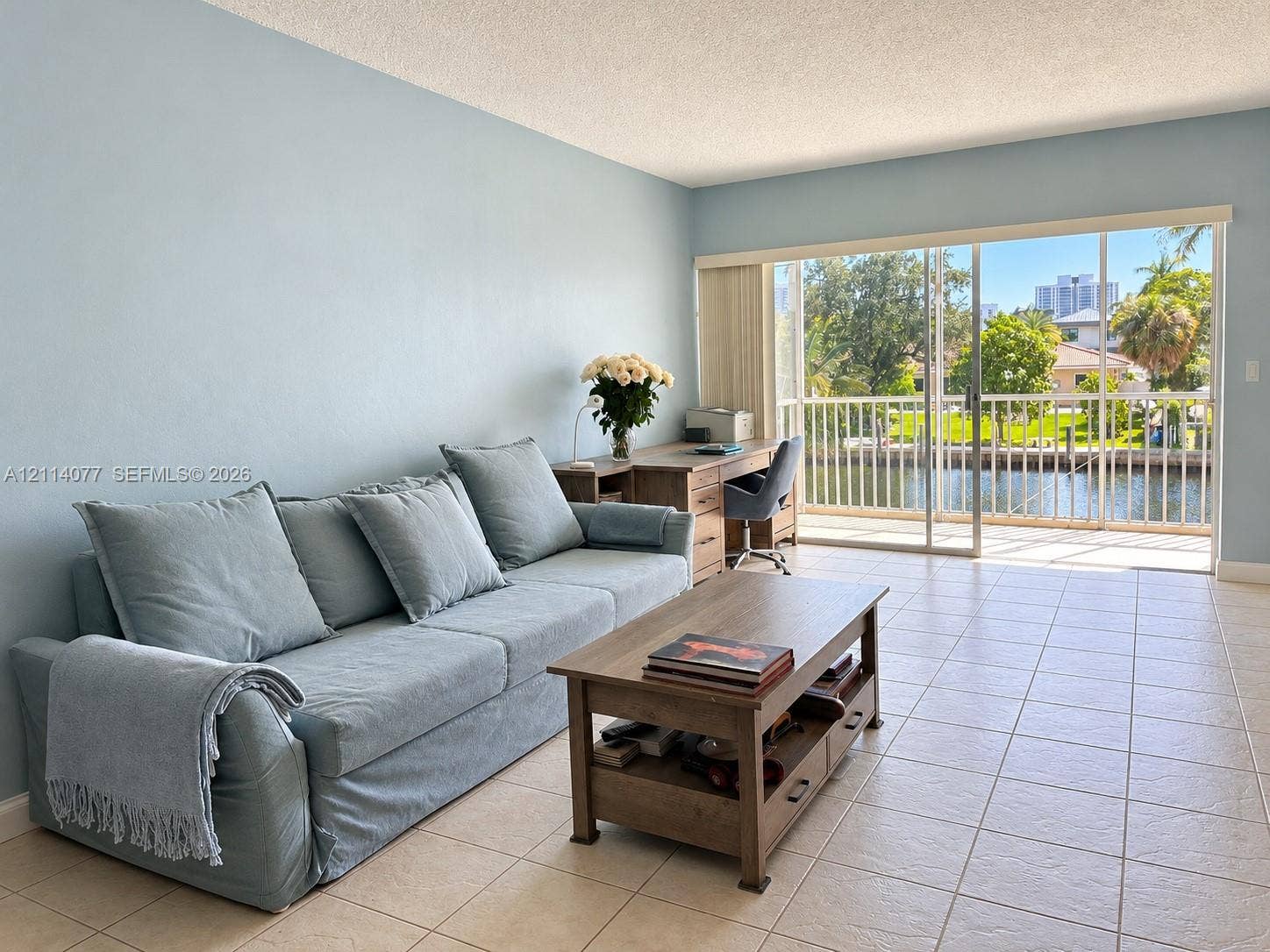 465 Paradise Isle Boulevard, #206, Hallandale Beach, Hallandale Beach, FL 33009 Large-format tile flooring, expansive sliding glass doors, and a private balcony with metal railing overlooking the waterway