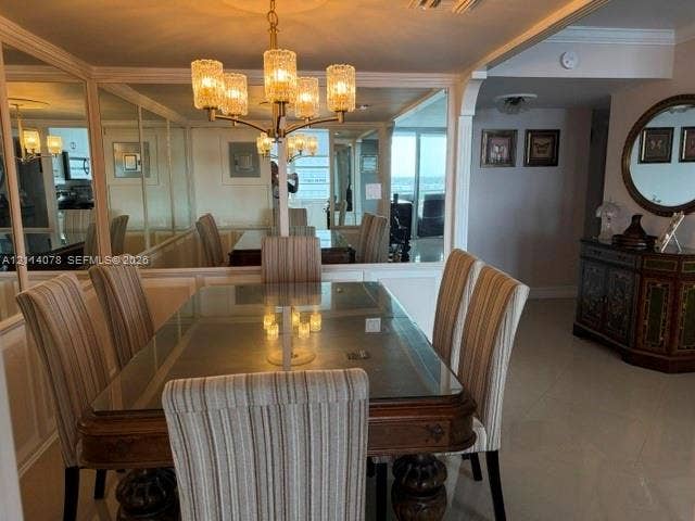 Dining area featuring large-scale wall mirrors, a multi-arm metallic chandelier with glass shades, arched architectural detailing, and tile flooring