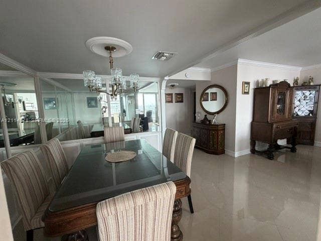 Dining area featuring large-format tile flooring, crown molding, a decorative ceiling medallion, an integrated wall mirror, and a multi-arm chandelier