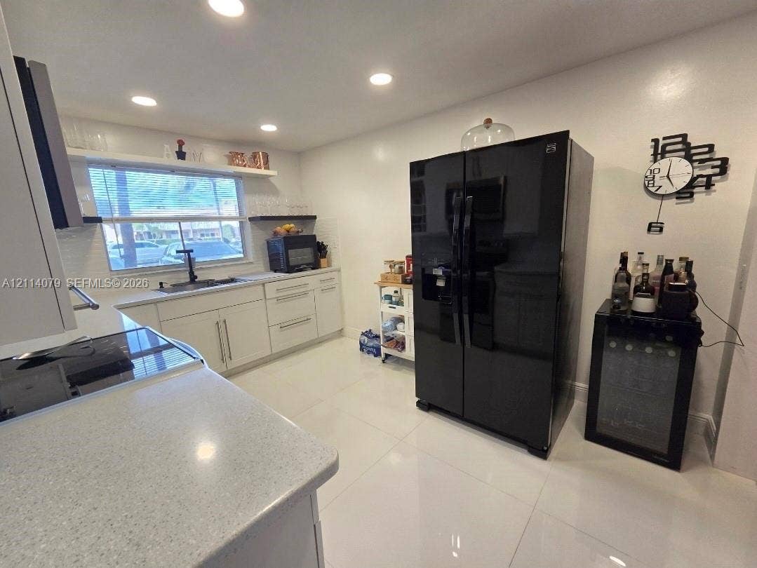 9241 Sunrise Lakes Boulevard, #109, Sunrise, FL 33322 Kitchen featuring white cabinetry, solid surface countertops, recessed lighting, and tile flooring