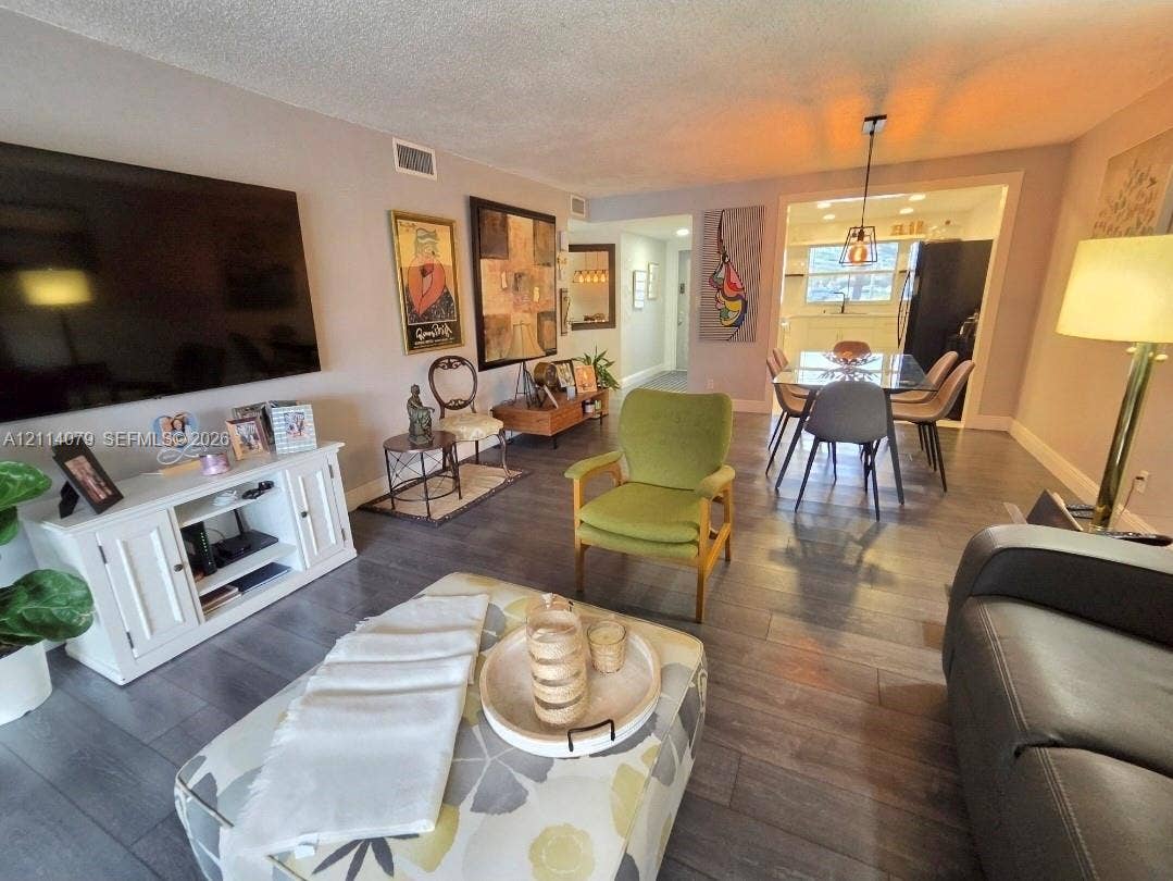 9241 Sunrise Lakes Boulevard, #109, Sunrise, FL 33322 Open concept interior featuring grey wood-finish flooring, recessed lighting, and a modern pendant light fixture