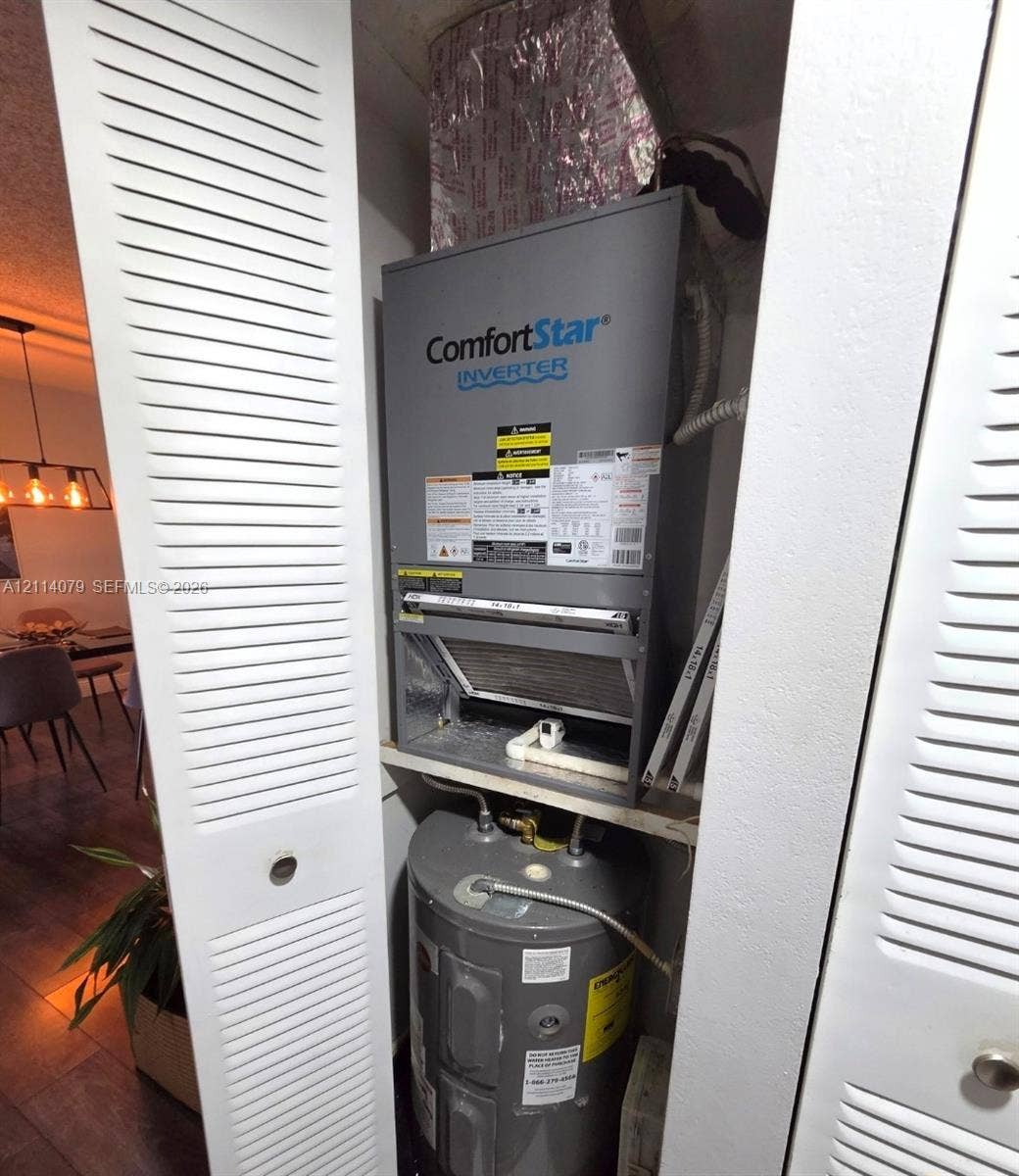 9241 Sunrise Lakes Boulevard, #109, Sunrise, FL 33322 Utility closet housing a ComfortStar inverter HVAC system and water heater, enclosed by dual white louvered doors