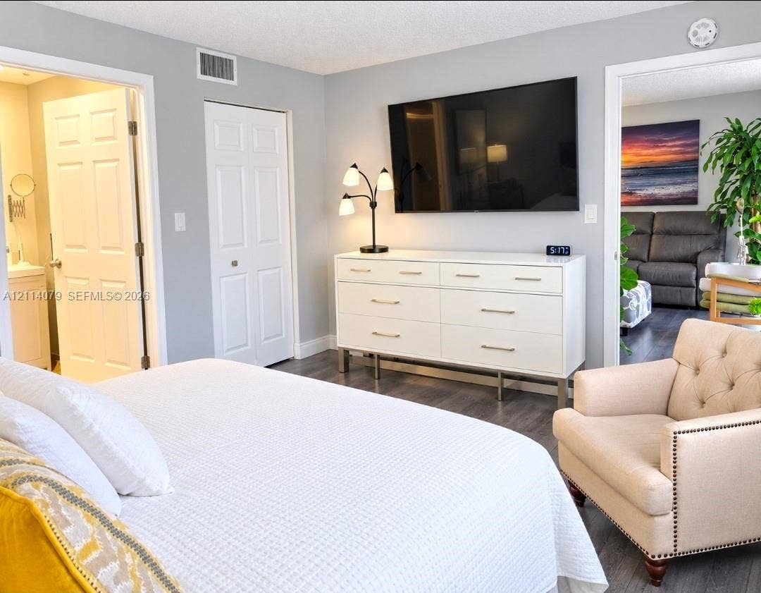9241 Sunrise Lakes Boulevard, #109, Sunrise, FL 33322 Neutral wall paint, wood-finish flooring, and white paneled interior doors