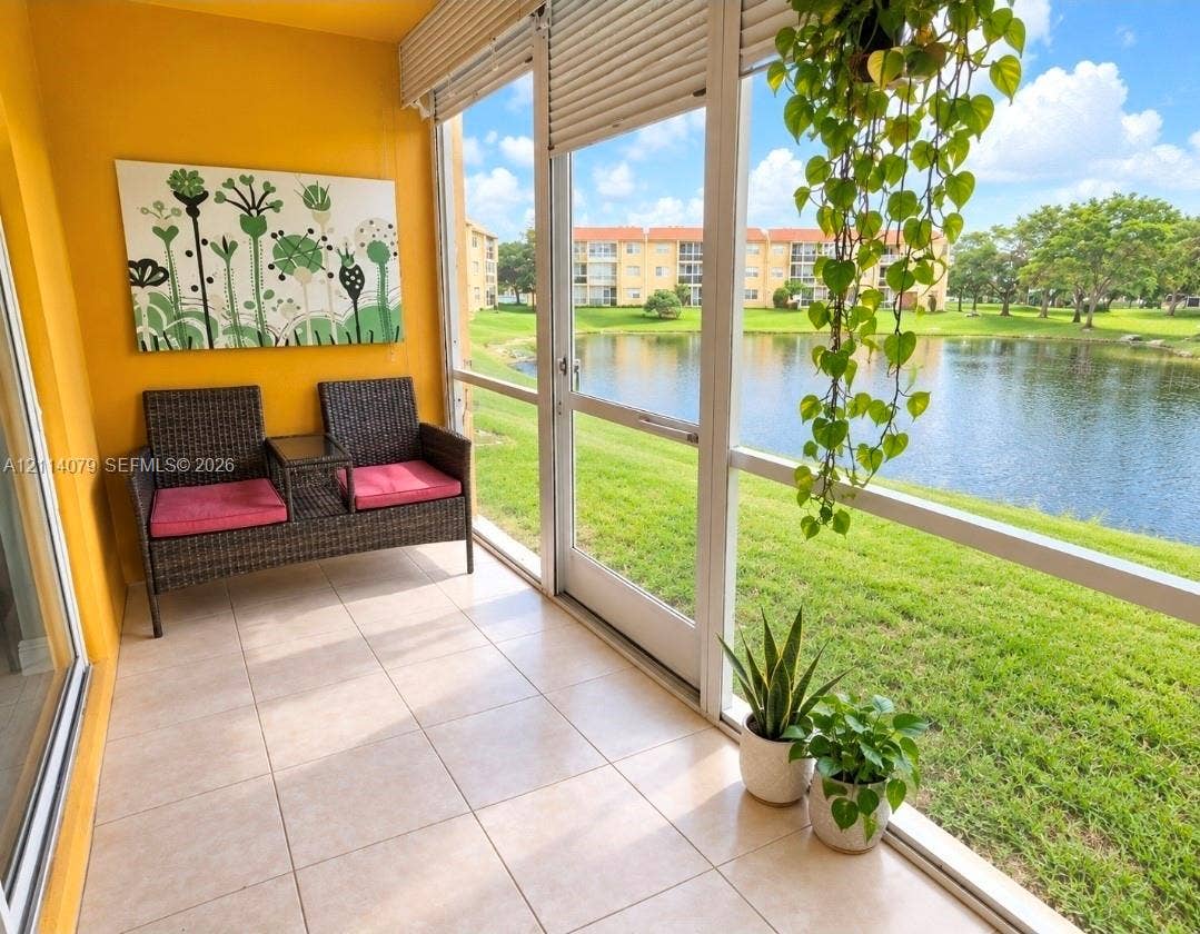 9241 Sunrise Lakes Boulevard, #109, Sunrise, FL 33322 Screened-in porch featuring large-format tile flooring, expansive floor-to-ceiling windows, and direct water exposure