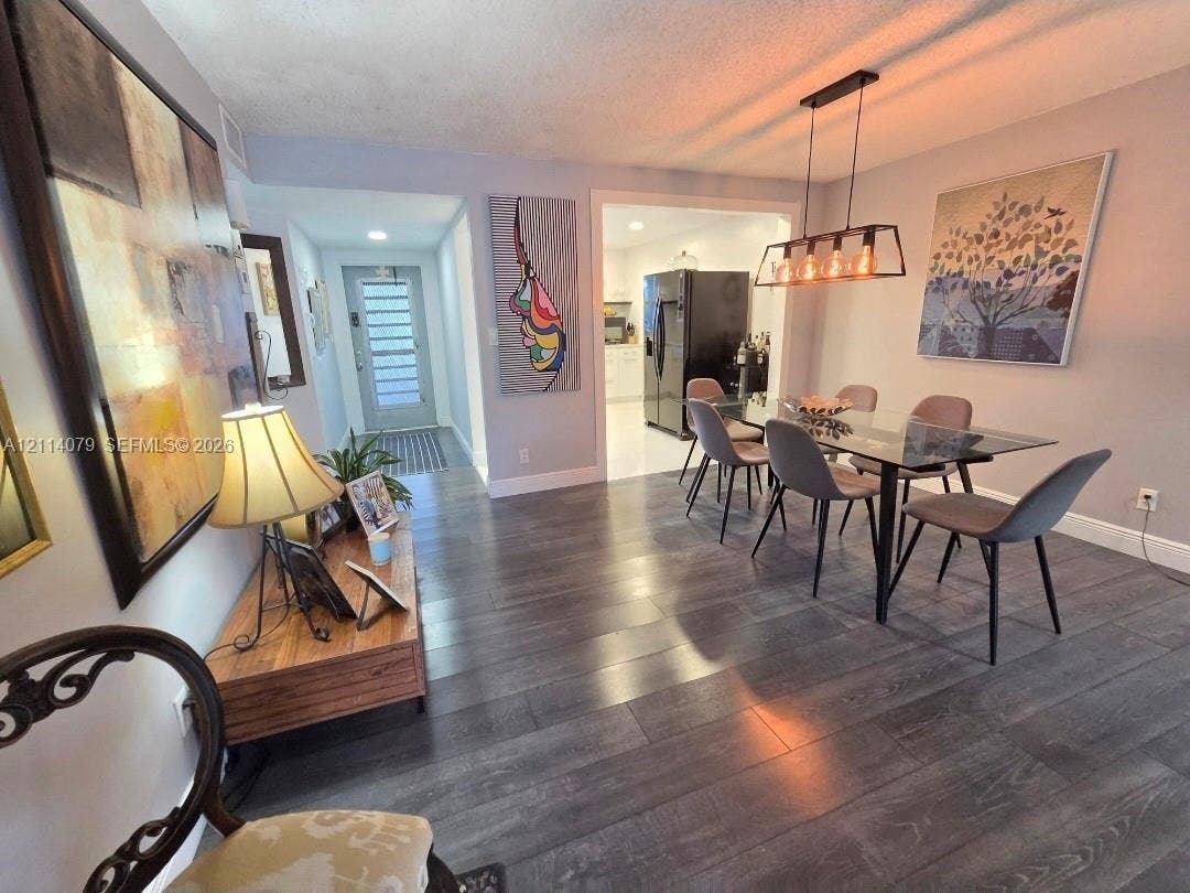 9241 Sunrise Lakes Boulevard, #109, Sunrise, FL 33322 Wood-finish flooring, rectangular multi-light pendant fixture, and glass-paneled entry door