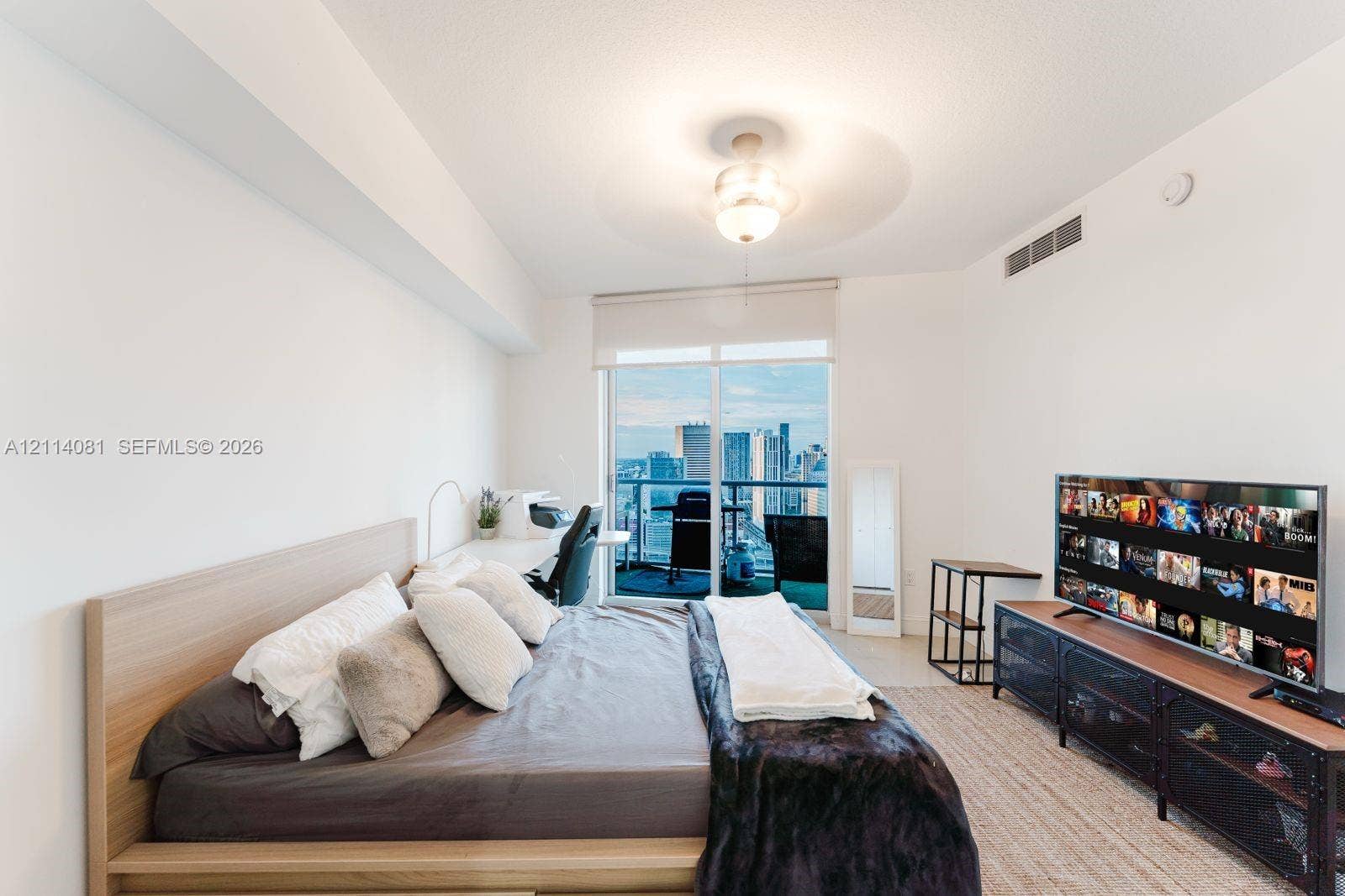 185 SW 7th Street, #3609, Miami, Miami, FL 33130 Floor-to-ceiling glass sliding door with roller shade, private balcony, neutral wall finishes, and integrated ceiling fan with lighting