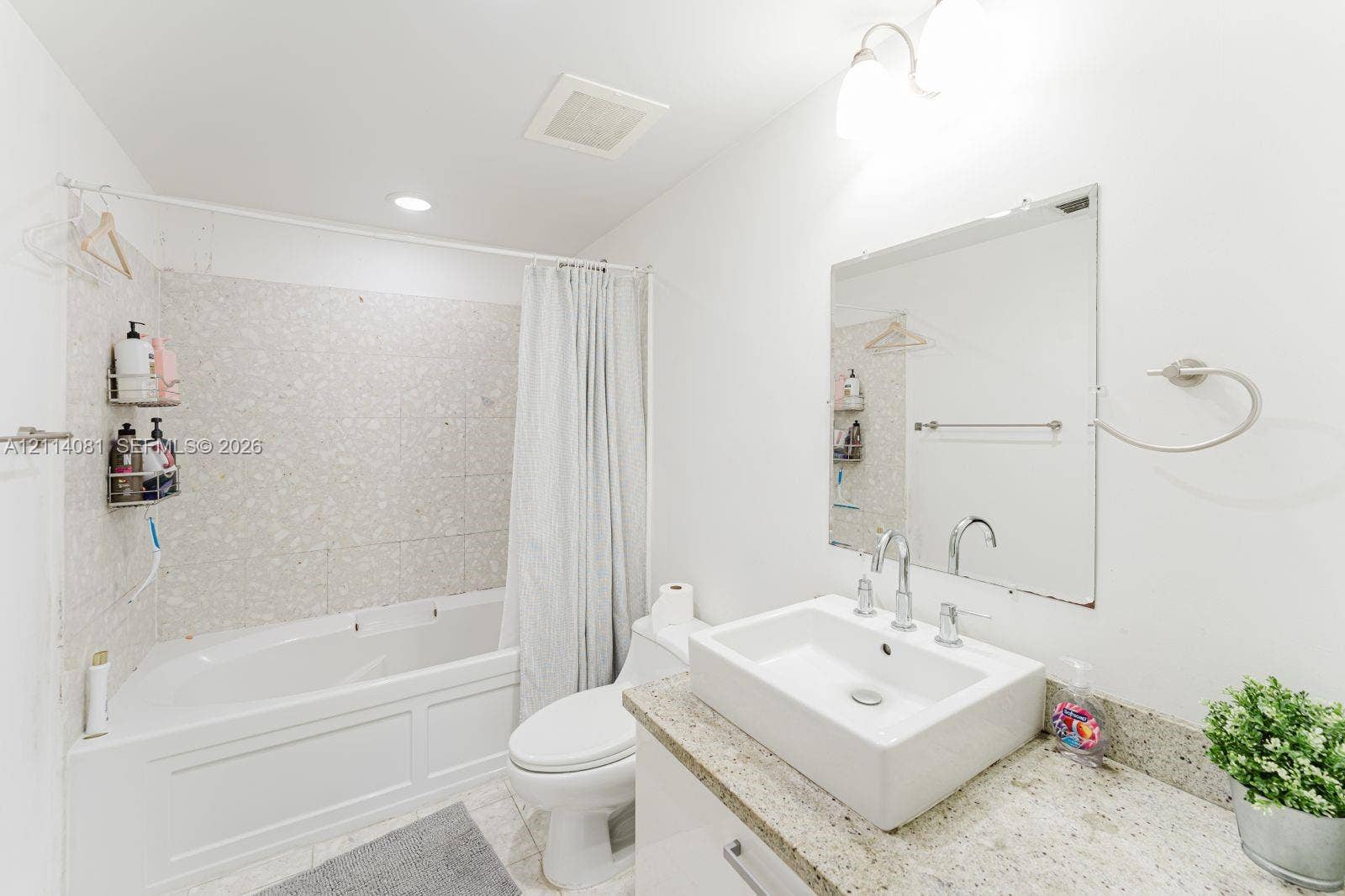 185 SW 7th Street, #3609, Miami, Miami, FL 33130 Bathroom featuring a vanity with an integrated vessel sink, stone-finish countertop, wall-mounted mirror, and a tub-shower combination with tile surround