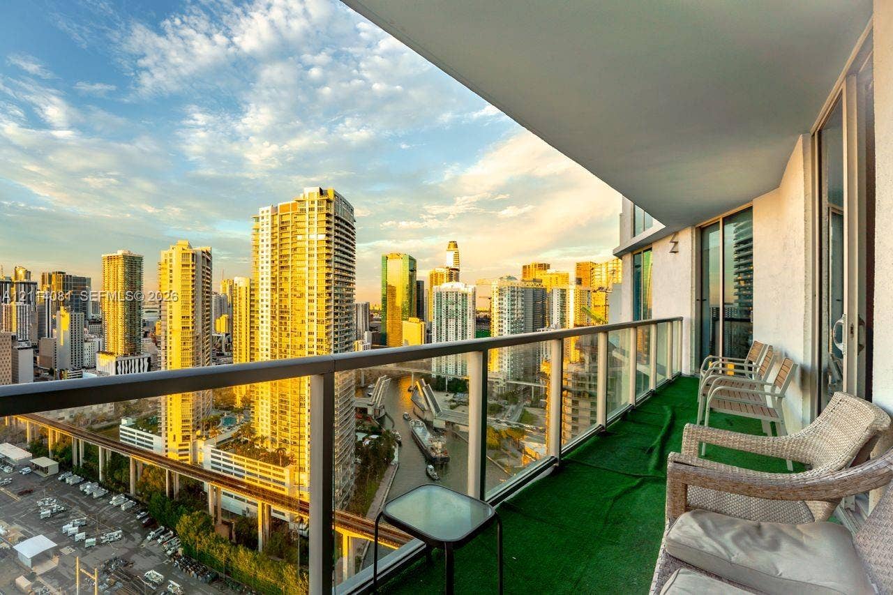 185 SW 7th Street, #3609, Miami, Miami, FL 33130 Covered balcony with glass and metal railings, showcasing an urban cityscape