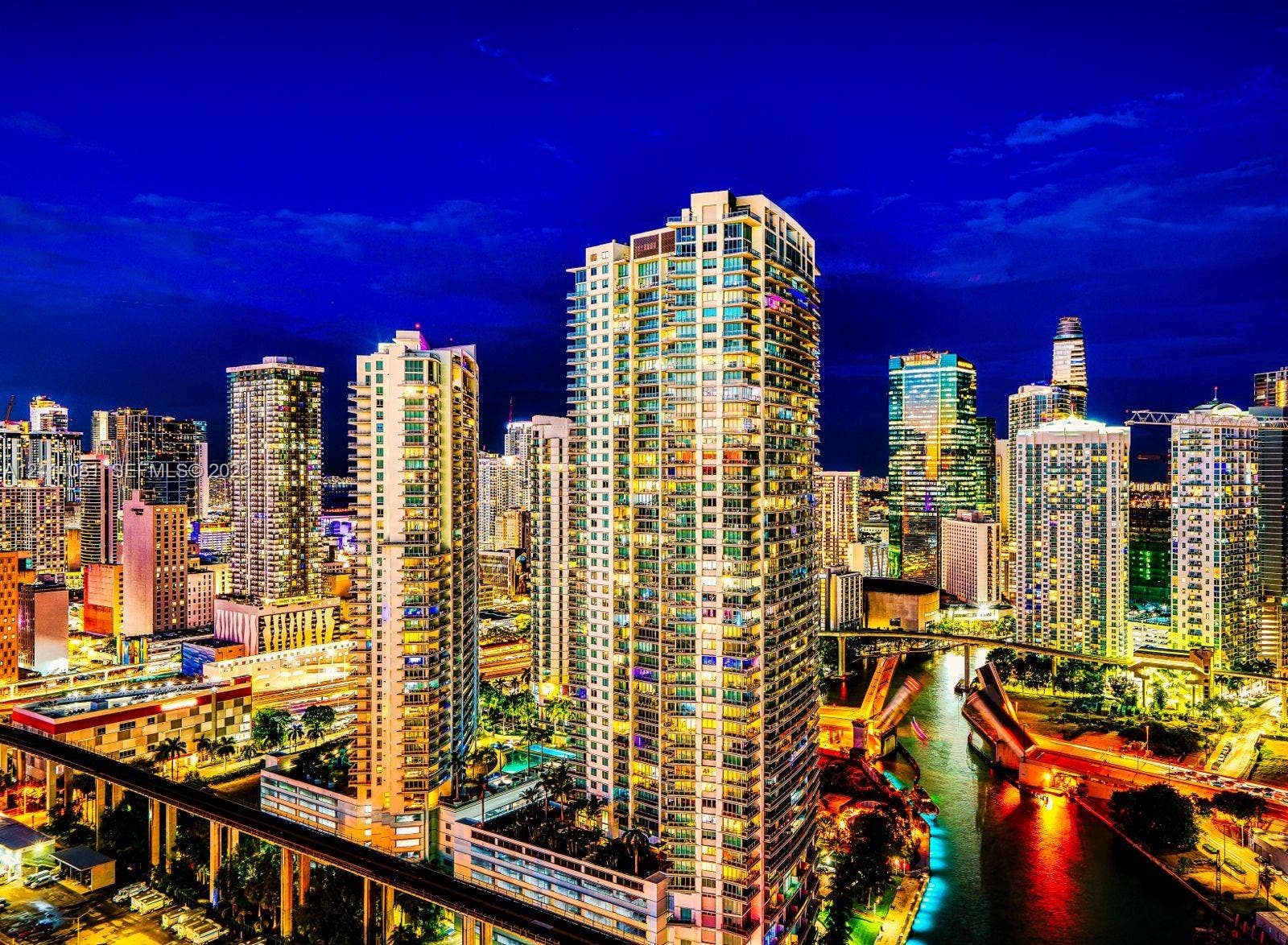 185 SW 7th Street, #3609, Miami, Miami, FL 33130 High-rise residential tower featuring glass-paneled balconies, floor-to-ceiling windows, and integrated exterior lighting, situated in a dense metropolitan center with a waterway