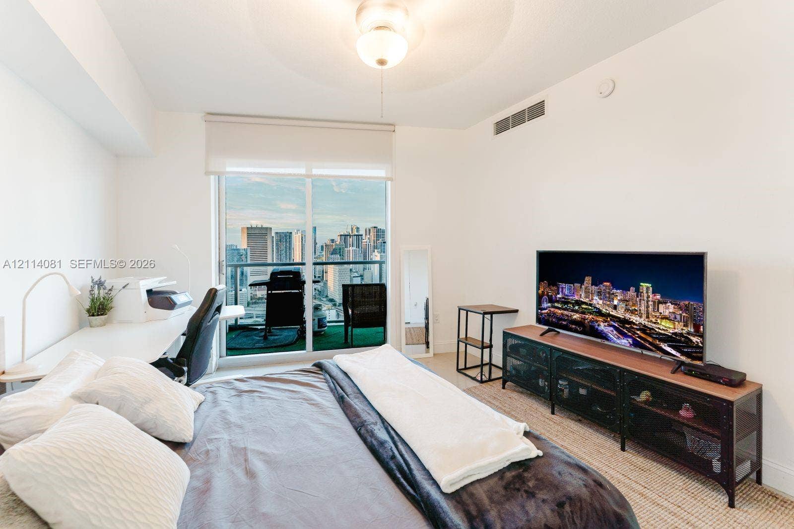 185 SW 7th Street, #3609, Miami, Miami, FL 33130 Floor-to-ceiling glass sliding door, private balcony, urban skyline backdrop, and central ceiling-mounted light fixture