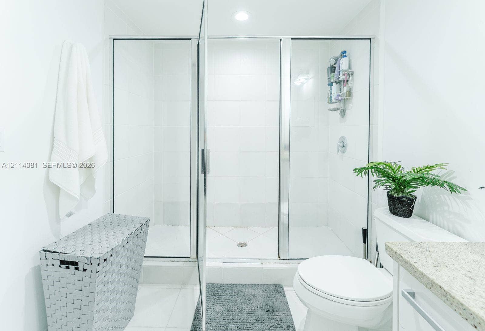 185 SW 7th Street, #3609, Miami, Miami, FL 33130 Walk-in shower with clear glass enclosure and chrome framing, complemented by a stone-finish countertop