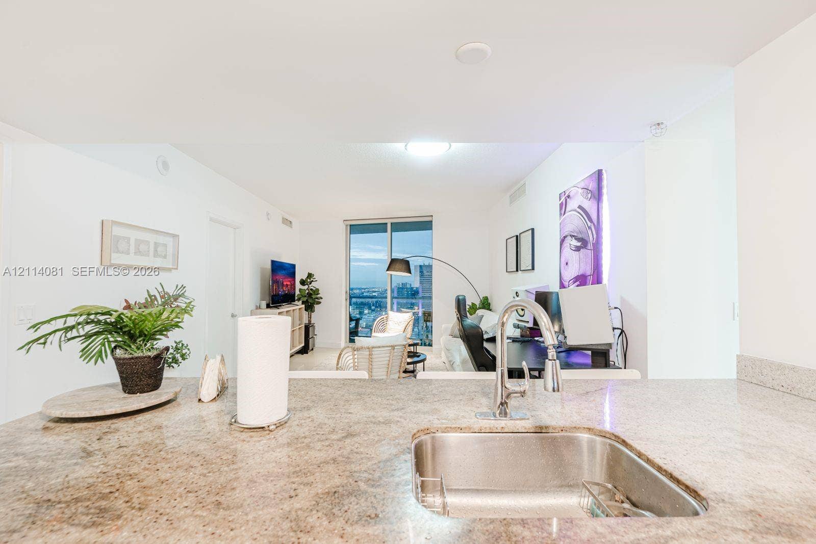 185 SW 7th Street, #3609, Miami, Miami, FL 33130 Kitchen peninsula featuring stone countertops, an undermount stainless steel sink, and a high-arc pull-down chrome faucet