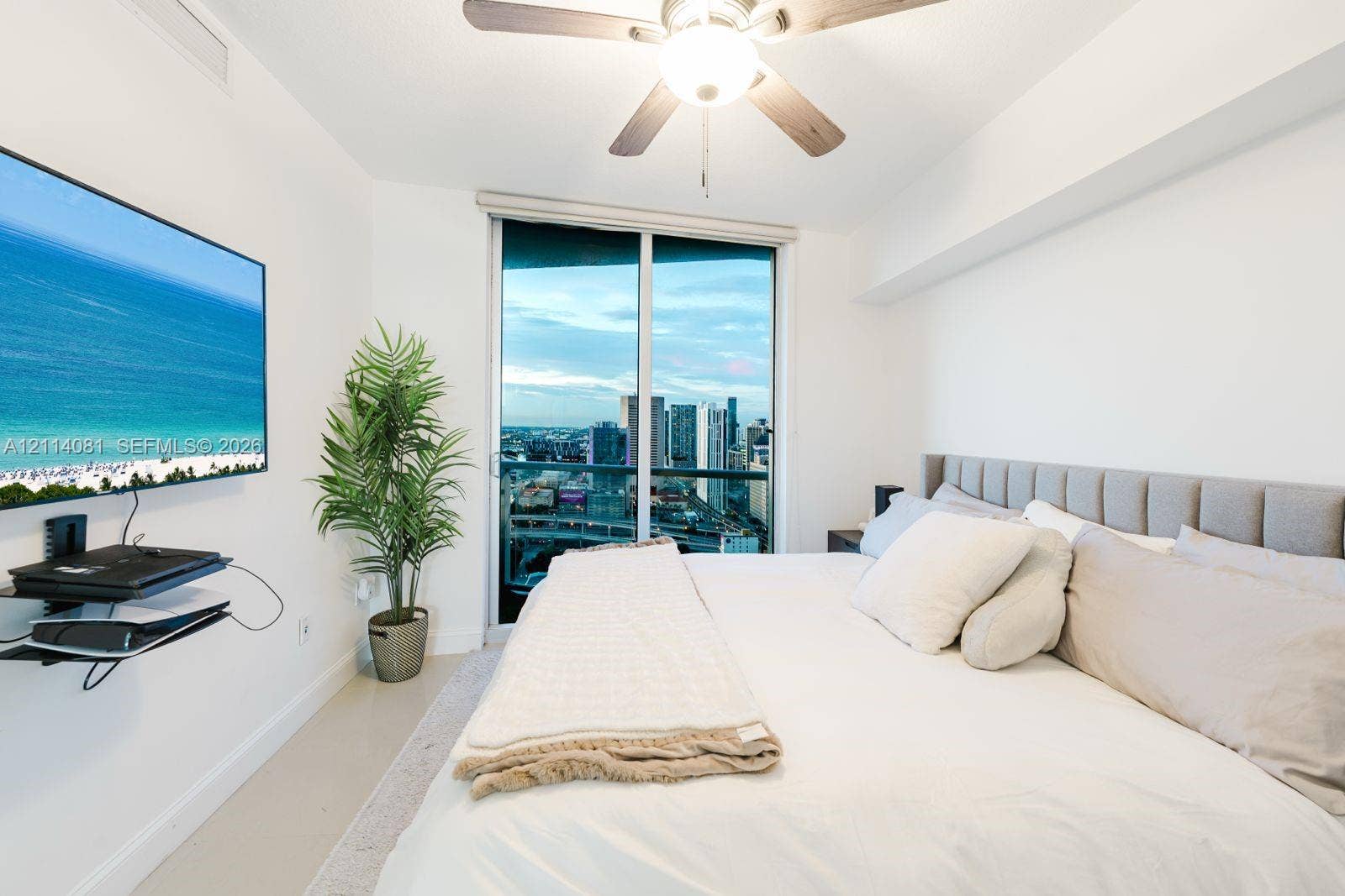 185 SW 7th Street, #3609, Miami, Miami, FL 33130 Floor-to-ceiling sliding glass door, ceiling fan with integrated lighting, and neutral-toned wall-to-wall flooring