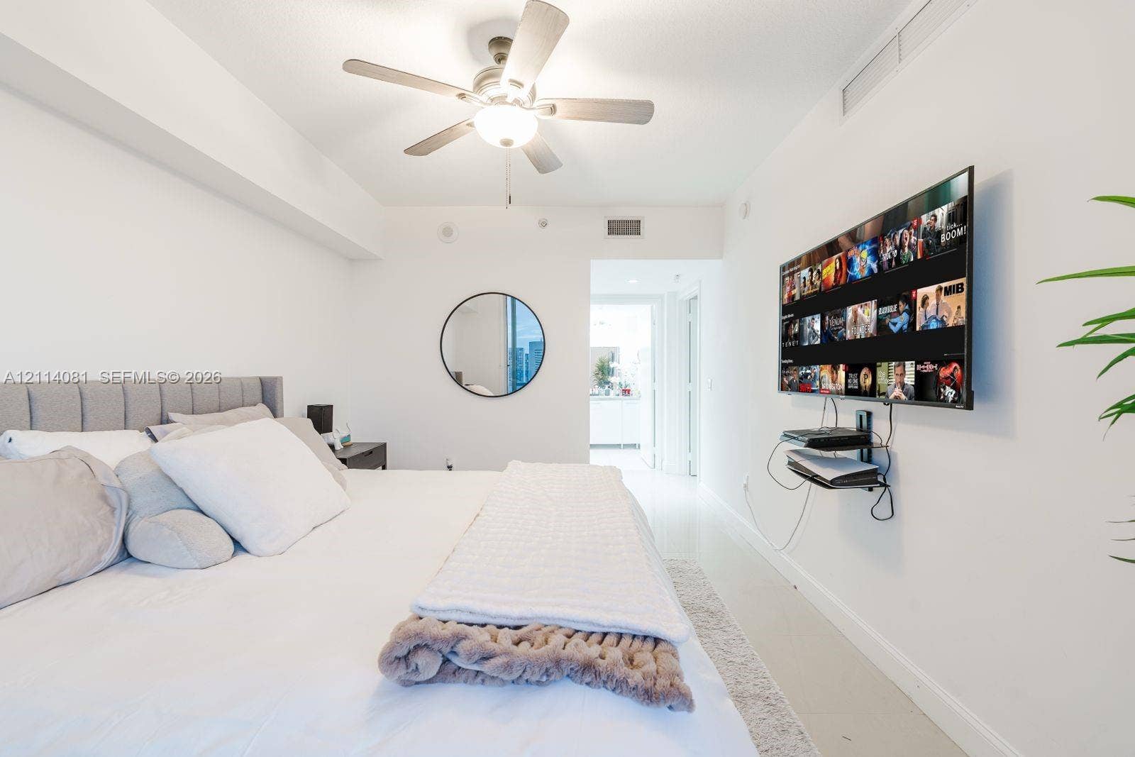 185 SW 7th Street, #3609, Miami, Miami, FL 33130 Neutral interior space featuring white walls, a ceiling-mounted light fixture with integrated fan, and a circular wall-mounted mirror