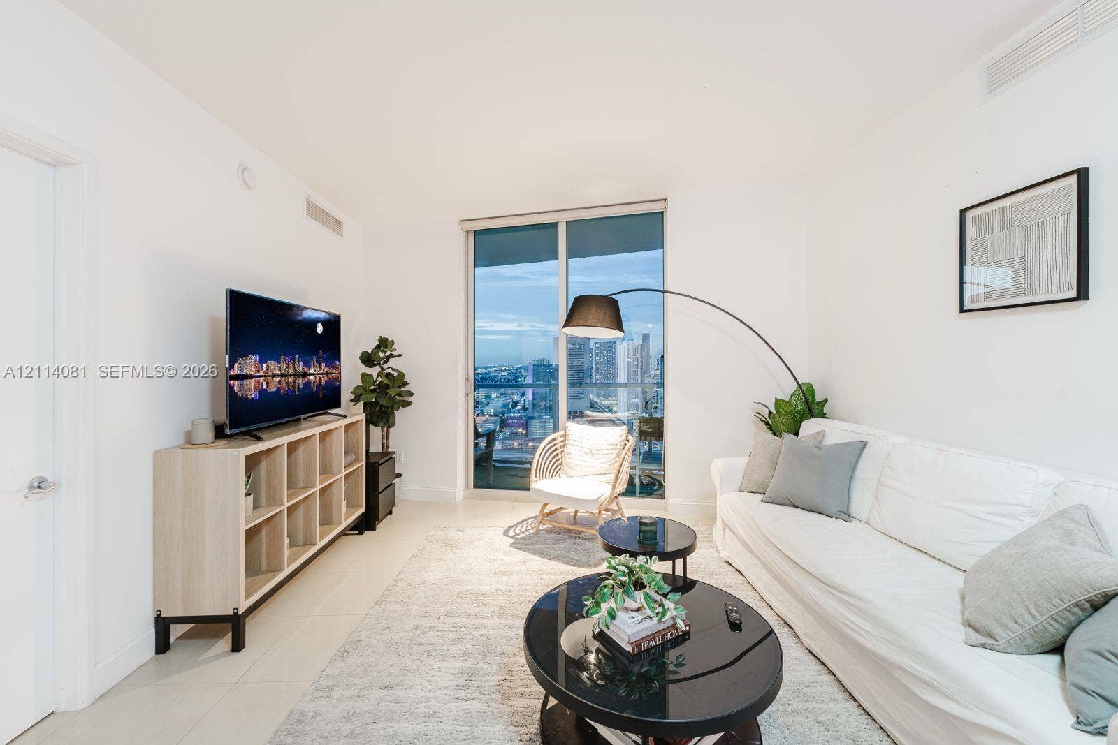 185 SW 7th Street, #3609, Miami, Miami, FL 33130 Floor-to-ceiling glass sliding door, neutral tiled flooring, and high-rise cityscape horizon
