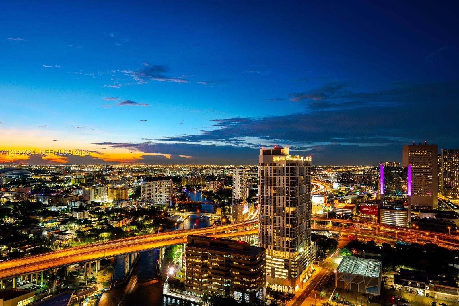 185 SW 7th Street, #3609, Miami, Miami, FL 33130 Aerial perspective featuring a high-rise structure, urban skyline, waterway, and elevated roadway infrastructure