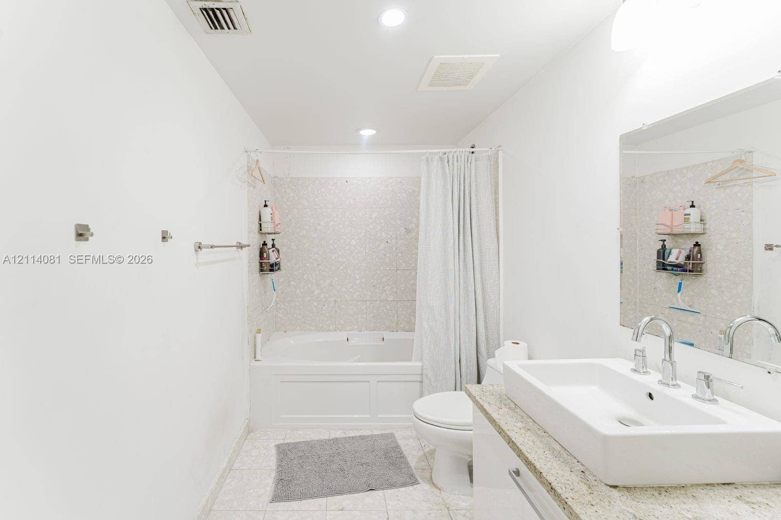185 SW 7th Street, #3609, Miami, Miami, FL 33130 Bathroom featuring a soaking tub with decorative tile surround, a rectangular vessel sink, stone-finish countertop, and recessed lighting