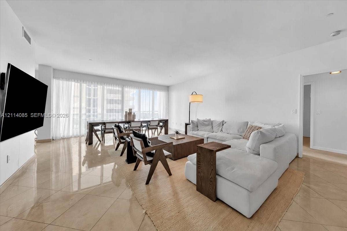 10101 Collins Avenue, #8D, Bal Harbour, FL 33154 Open-concept room with large-format tile flooring, floor-to-ceiling windows, and recessed lighting