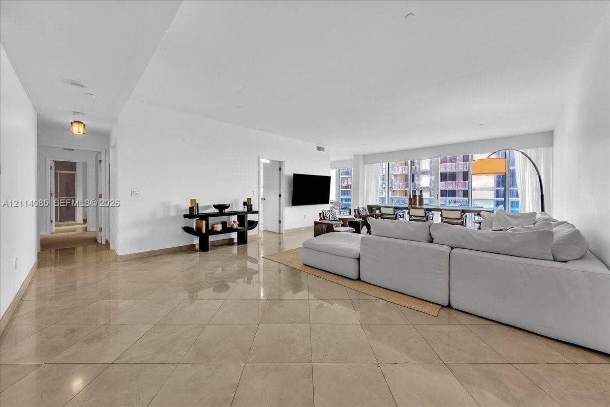 10101 Collins Avenue, #8D, Bal Harbour, FL 33154 Large-format tile flooring, recessed ceiling lighting, and floor-to-ceiling windows featuring exterior building architecture