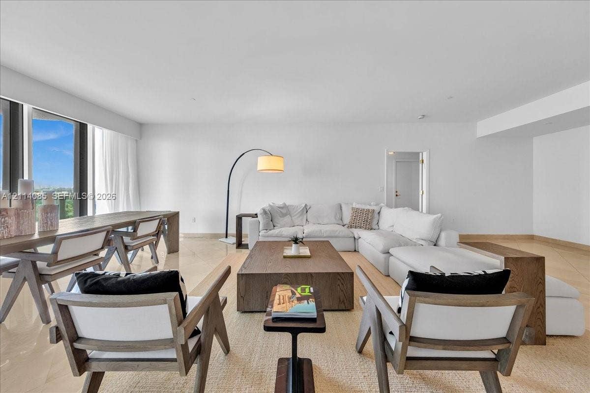 10101 Collins Avenue, #8D, Bal Harbour, FL 33154 Open-concept interior featuring large-format stone flooring, expansive floor-to-ceiling windows, and neutral-toned wall finishes