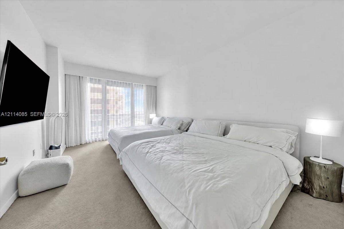 10101 Collins Avenue, #8D, Bal Harbour, FL 33154 Wall-to-wall carpeting, floor-to-ceiling windows, and sheer drapery