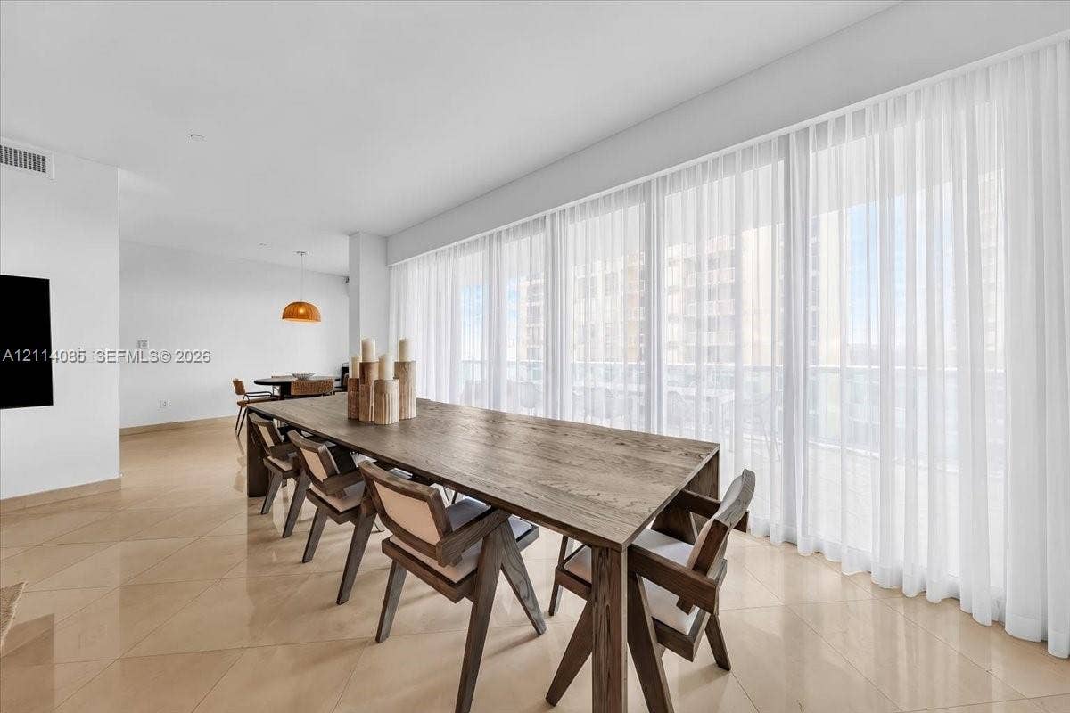 10101 Collins Avenue, #8D, Bal Harbour, FL 33154 Open-concept interior featuring large-format tile flooring, recessed lighting, and a continuous wall of floor-to-ceiling windows