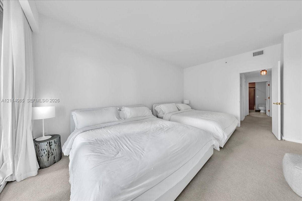 10101 Collins Avenue, #8D, Bal Harbour, FL 33154 Neutral-toned carpeting, full-height window treatments, and interior door with metallic hardware