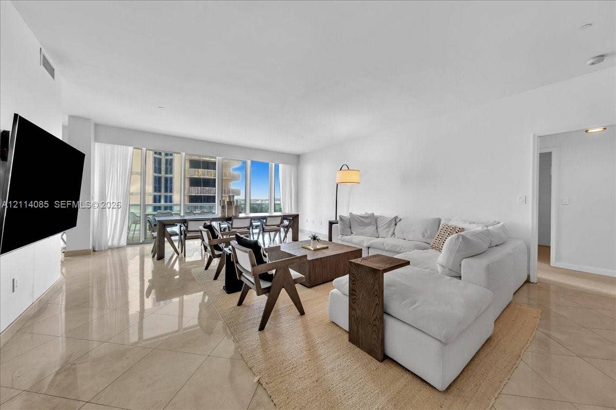 10101 Collins Avenue, #8D, Bal Harbour, FL 33154 Open-concept living area featuring polished tile flooring, floor-to-ceiling windows, and recessed lighting