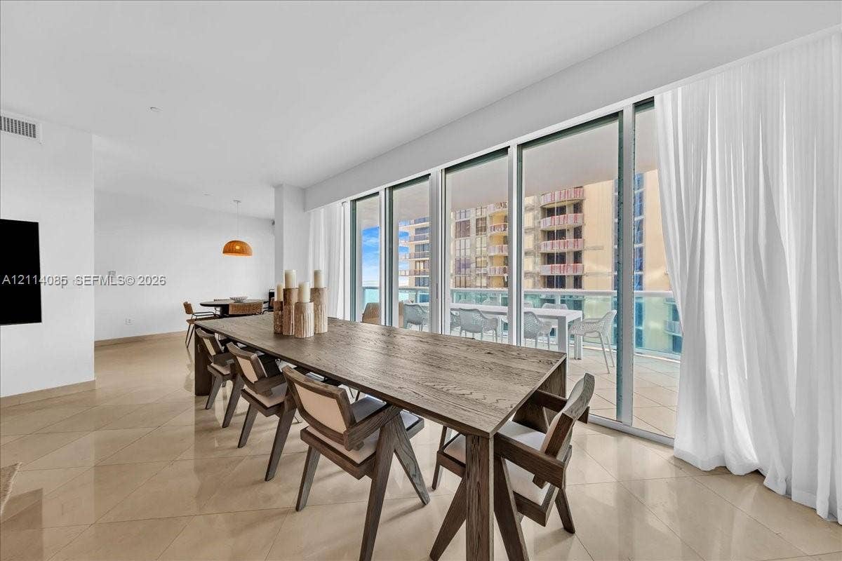 10101 Collins Avenue, #8D, Bal Harbour, FL 33154 Floor-to-ceiling sliding glass doors, neutral tile flooring, and a covered balcony