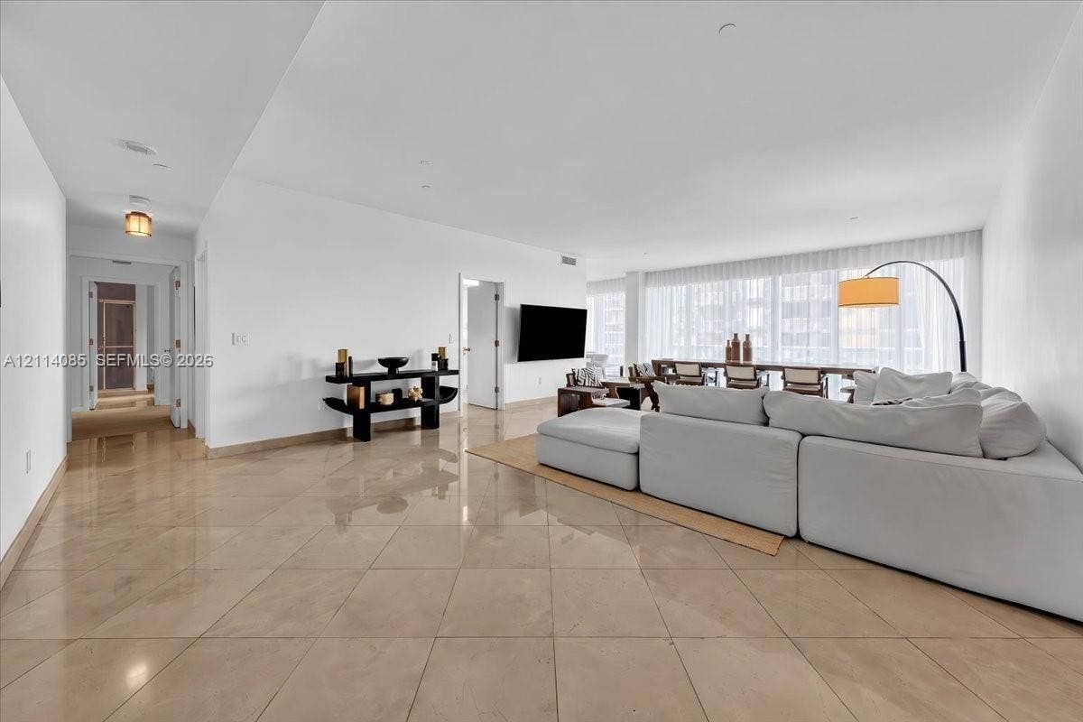 10101 Collins Avenue, #8D, Bal Harbour, FL 33154 Large-format tile flooring, recessed ceiling lighting, and floor-to-ceiling windows with integrated drapery tracks