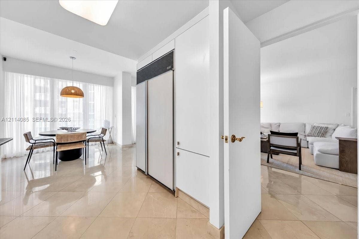 10101 Collins Avenue, #8D, Bal Harbour, FL 33154 High-gloss stone flooring, floor-to-ceiling drapery, built-in panel-ready refrigeration, and minimalist flat-panel cabinetry