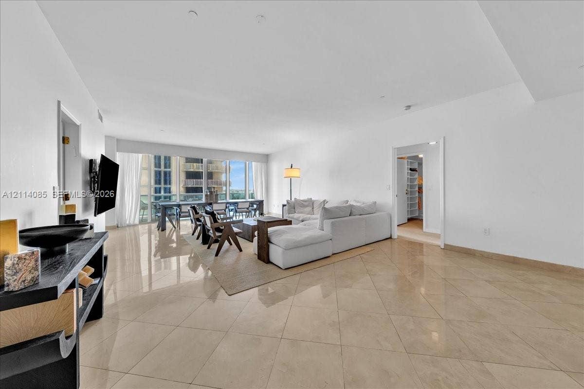 10101 Collins Avenue, #8D, Bal Harbour, FL 33154 Open-concept living area with large-format tile flooring and expansive floor-to-ceiling windows