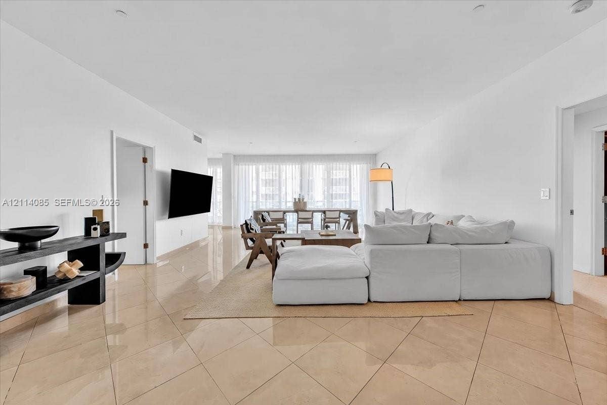 10101 Collins Avenue, #8D, Bal Harbour, FL 33154 Open-concept living space featuring high-gloss tile flooring, recessed ceiling lighting, and expansive floor-to-ceiling windows