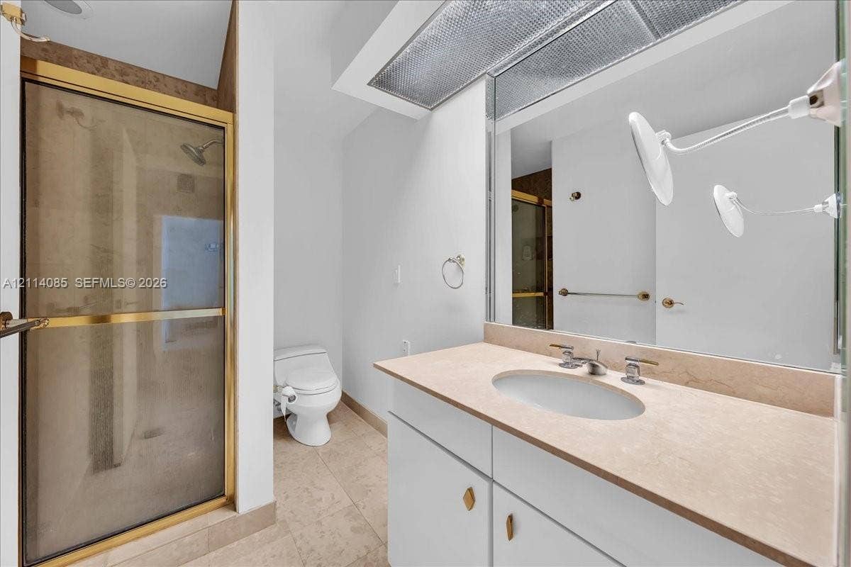 10101 Collins Avenue, #8D, Bal Harbour, FL 33154 Bathroom featuring a vanity with stone-finish countertop, undermount sink, and integrated cabinetry