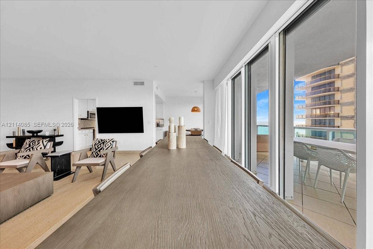 10101 Collins Avenue, #8D, Bal Harbour, FL 33154 Open-concept floor plan featuring wood-finish flooring, sliding glass door panels, and a balcony with a glass railing