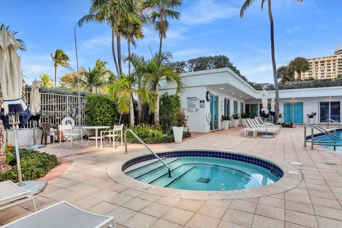 10101 Collins Avenue, #8D, Bal Harbour, FL 33154 In-ground spa with tile surround, extensive paver patio, integrated swimming pool, and mature landscaping