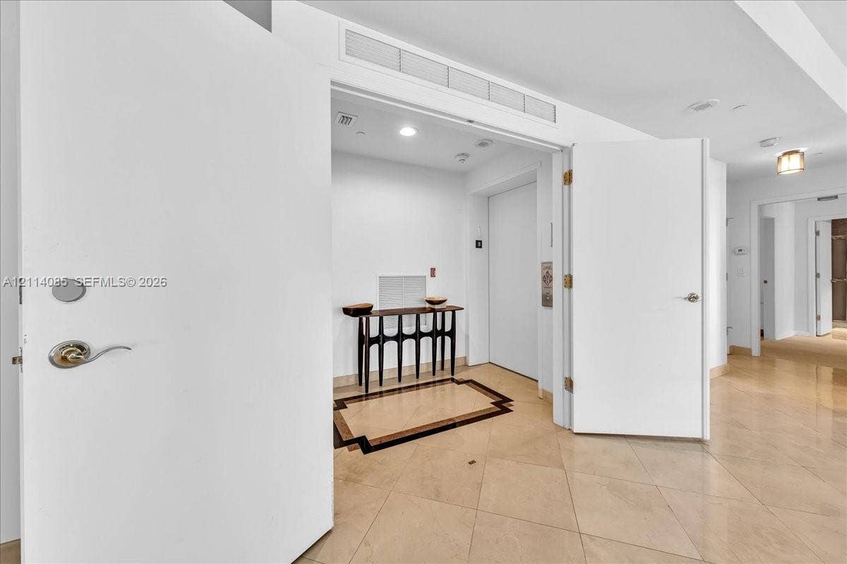 10101 Collins Avenue, #8D, Bal Harbour, FL 33154 Neutral tile flooring featuring a decorative inlaid border, double door entry, and recessed lighting